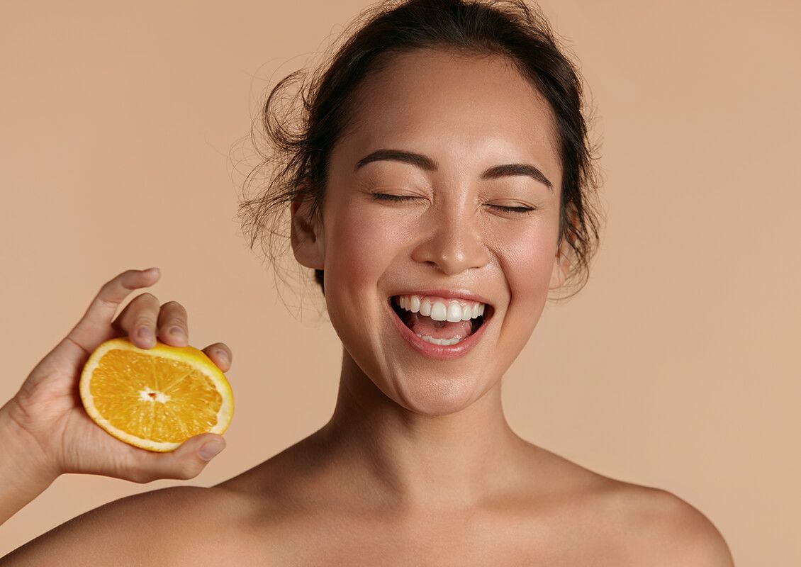 Frau hält eine geöffnete Pomelo