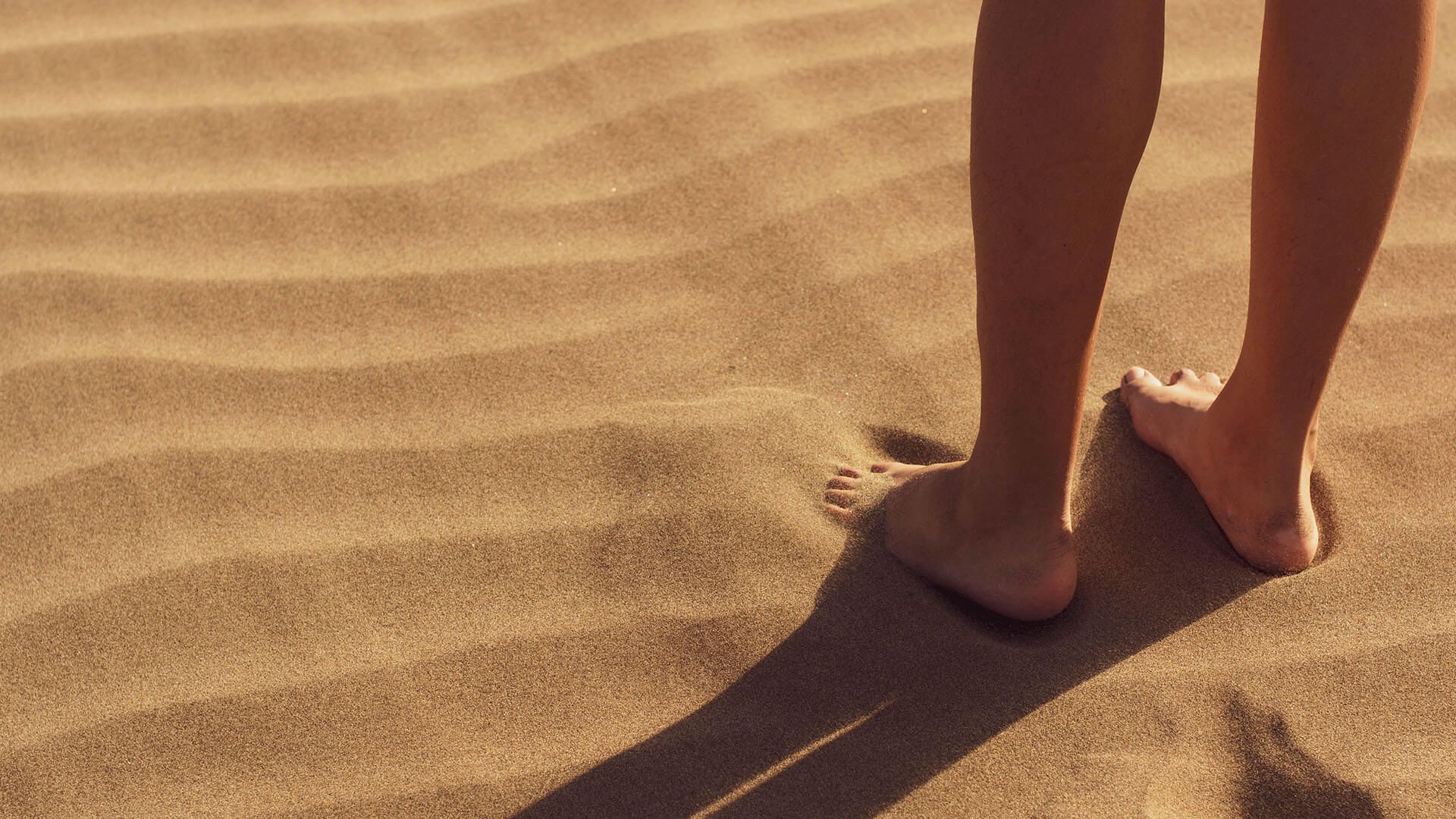 Frau die durch Sand läuft